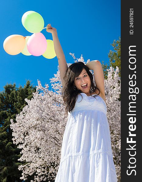 Young beautiful woman playing with colorful balloons, smiling and celebrating love and life in a spring scene. Young beautiful woman playing with colorful balloons, smiling and celebrating love and life in a spring scene.