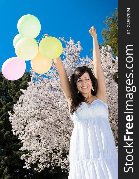 Young beautiful woman playing with colorful balloons, smiling and celebrating love and life in a spring scene. Young beautiful woman playing with colorful balloons, smiling and celebrating love and life in a spring scene.