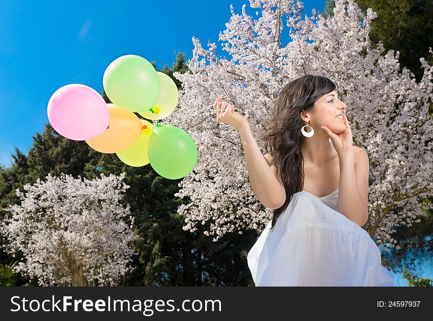Young beautiful woman playing with colorful balloons, smiling and celebrating love and life in a spring scene. Young beautiful woman playing with colorful balloons, smiling and celebrating love and life in a spring scene.