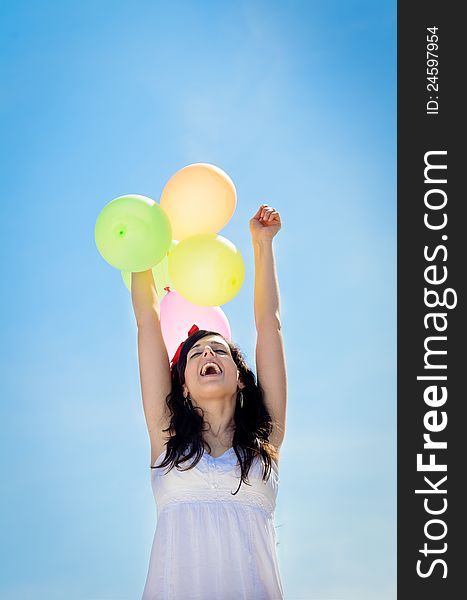 Beautiful brunette woman is celebrating and showing her happiness playing and having fun with colorful balloons. Beautiful brunette woman is celebrating and showing her happiness playing and having fun with colorful balloons.