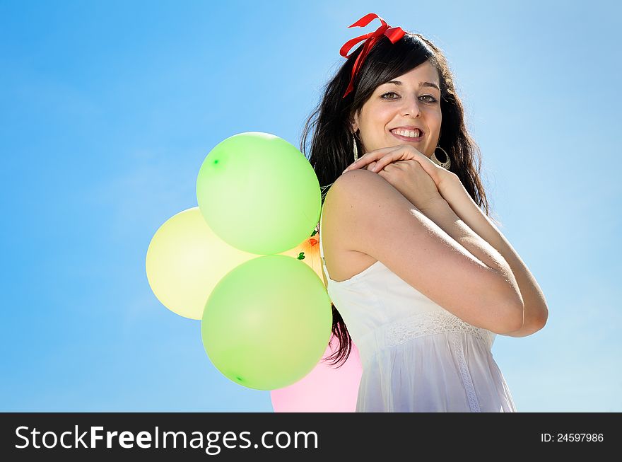 Beautiful brunette woman shows her happiness playing and having fun with colorful balloons. Beautiful brunette woman shows her happiness playing and having fun with colorful balloons.