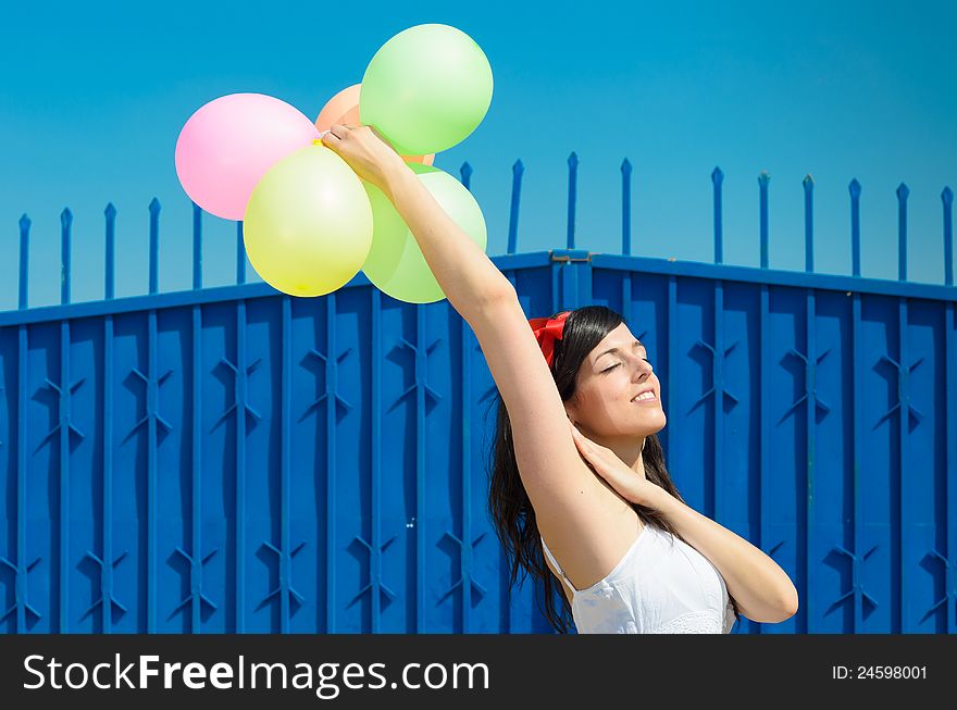 Young beautiful woman playing with colorful balloons, smiling and celebrating love and life in a spring scene. Young beautiful woman playing with colorful balloons, smiling and celebrating love and life in a spring scene.