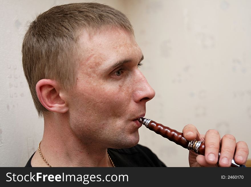 The man relaxs with hookah at home
