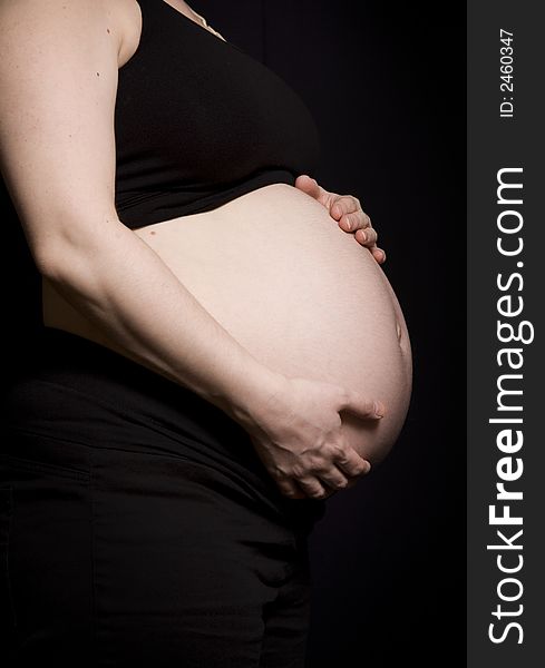 Side profile of a woman's pregnant belly. Side profile of a woman's pregnant belly