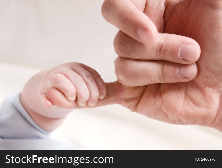 Small baby hand holding on to dad's finger. Small baby hand holding on to dad's finger
