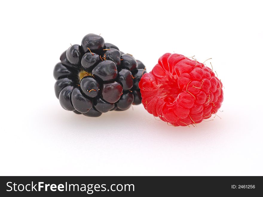 A plump and delicious raspberry and blackberry shot against a white background. A plump and delicious raspberry and blackberry shot against a white background