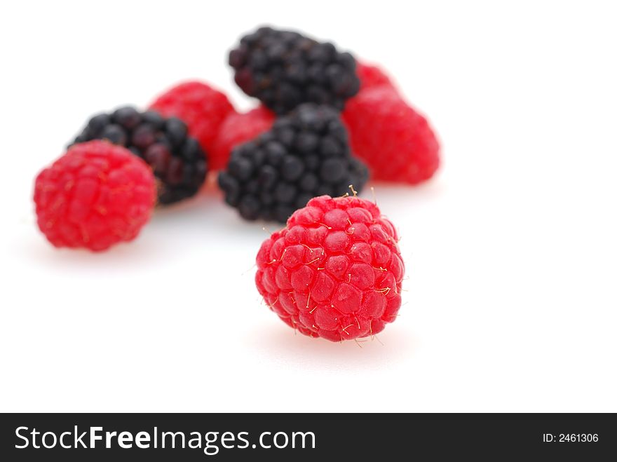 A plump and delicious raspberry and blackberry shot against a white background. A plump and delicious raspberry and blackberry shot against a white background