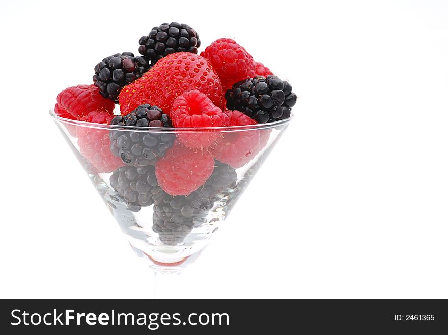 Plump and delicious raspberry and blackberry and strawberry shot in a glass against a white background. Plump and delicious raspberry and blackberry and strawberry shot in a glass against a white background
