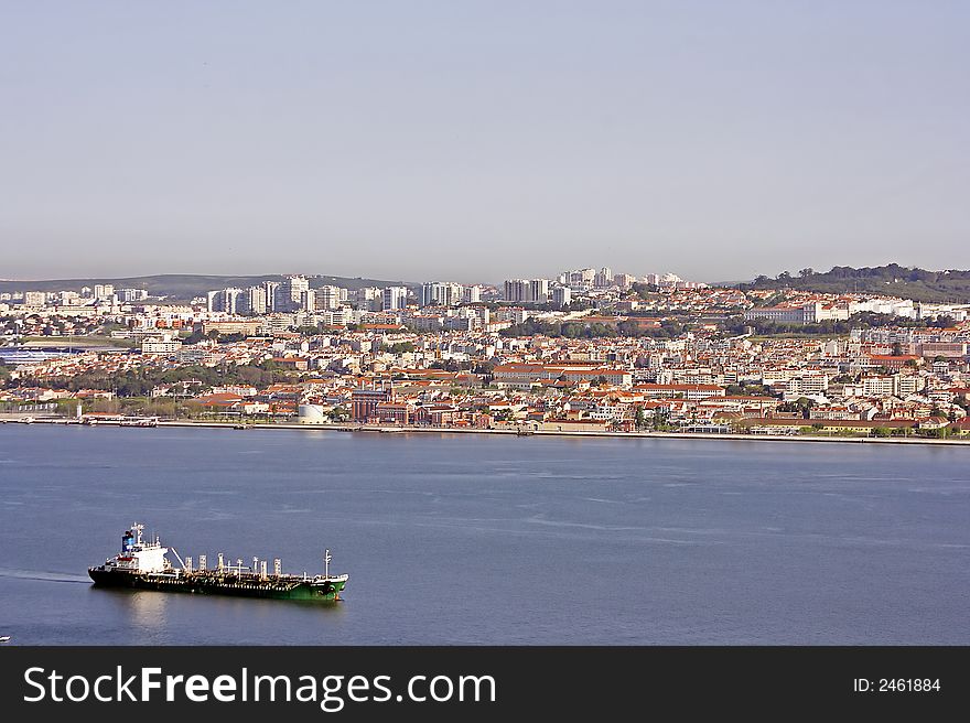 Cargo ship on the river Tagus with Lisbon in the background in Portugal. Cargo ship on the river Tagus with Lisbon in the background in Portugal