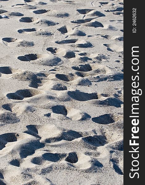 Numerous footprints imprinted in beach sand. Numerous footprints imprinted in beach sand