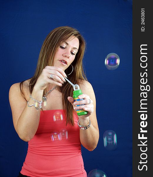 Portrait of a beautiful young woman blowing bubbles