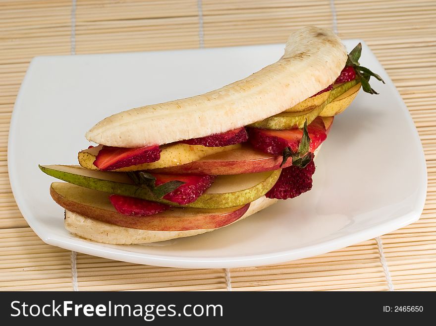 Mixed fruits looking like sandwich on white plate