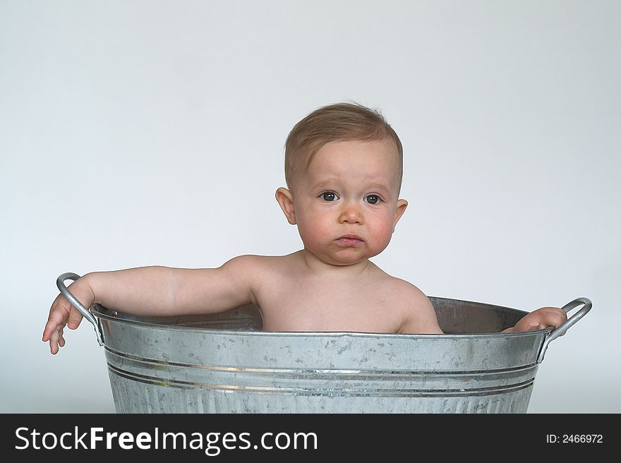 Image of cute baby sitting in a galvanized tub. Image of cute baby sitting in a galvanized tub