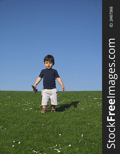 Child standing in field over deep blue sky