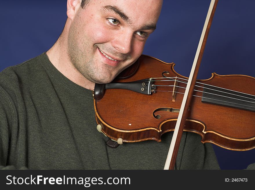 Portrait of man playing violon over blue background