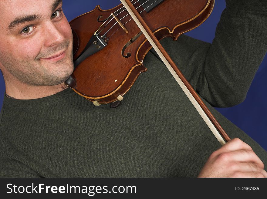 Portrait of man playing violon over blue background