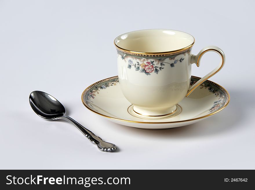 Saucer and Cup with floral patterns and spoon over a white background. Saucer and Cup with floral patterns and spoon over a white background.