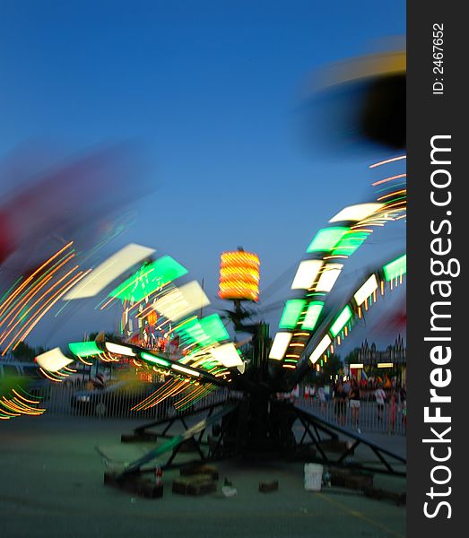 Amusement park with ride at high speed with colorful lights at dusk. Amusement park with ride at high speed with colorful lights at dusk.