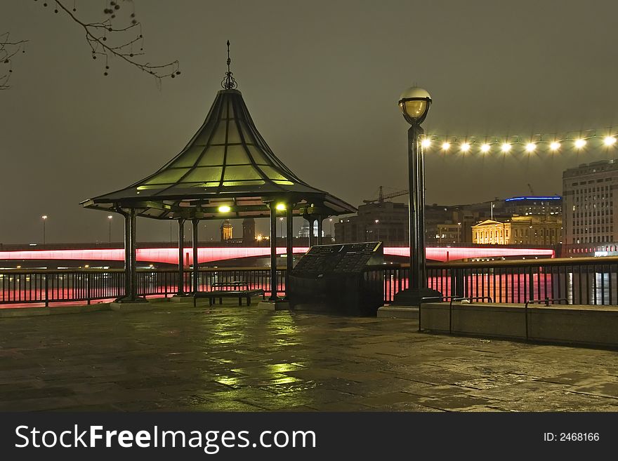 Small illuminated pavilion on the Thames bank