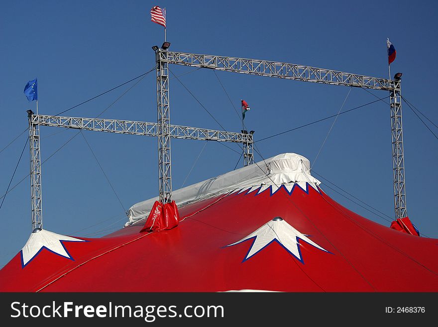 The top of a coloured circus tent on a blue sky. The top of a coloured circus tent on a blue sky