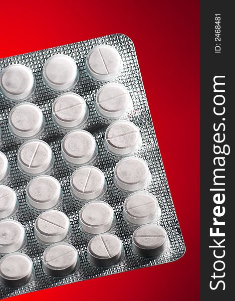 White tablets in packing on an red background. White tablets in packing on an red background
