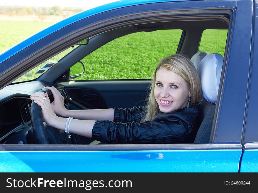Happy girl in the dark blue car. Happy girl in the dark blue car