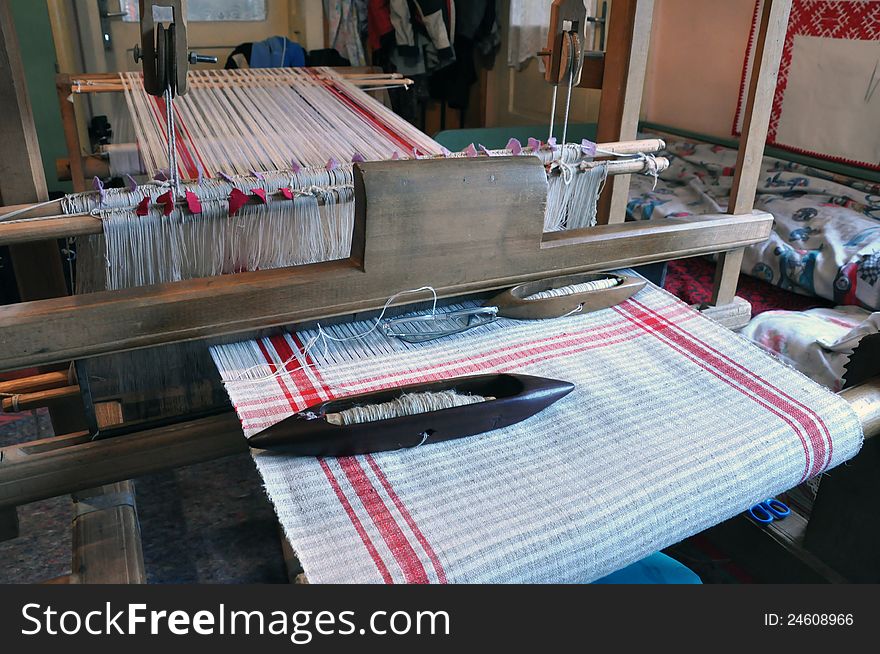 Wooden loom with strings of cloth