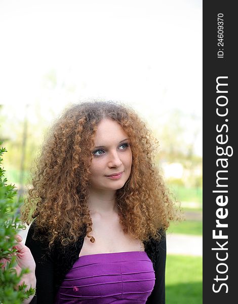 Curly girl portrait outdoors in the summer