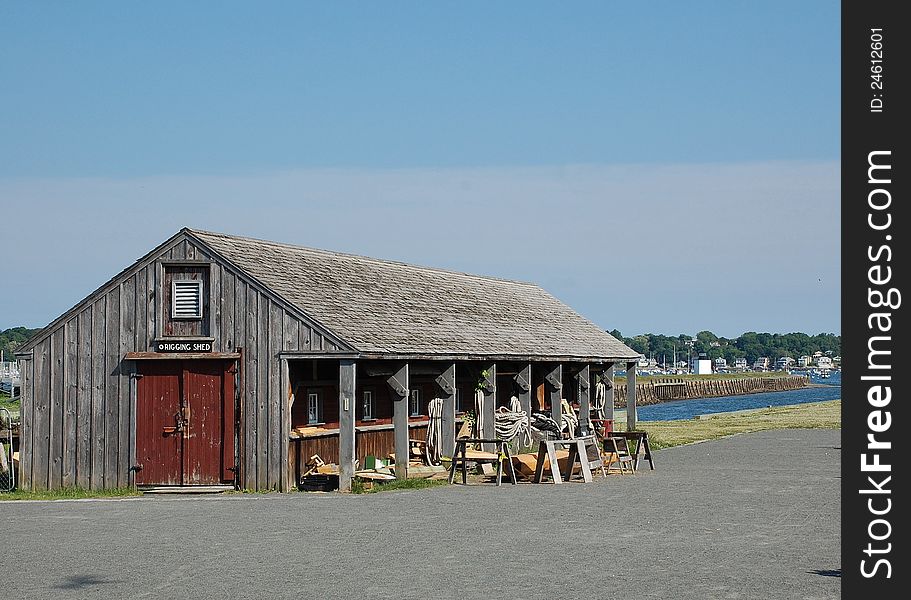 The historical rigging shed of the wharf with dark red doors, Salem harbor, MA. The historical rigging shed of the wharf with dark red doors, Salem harbor, MA