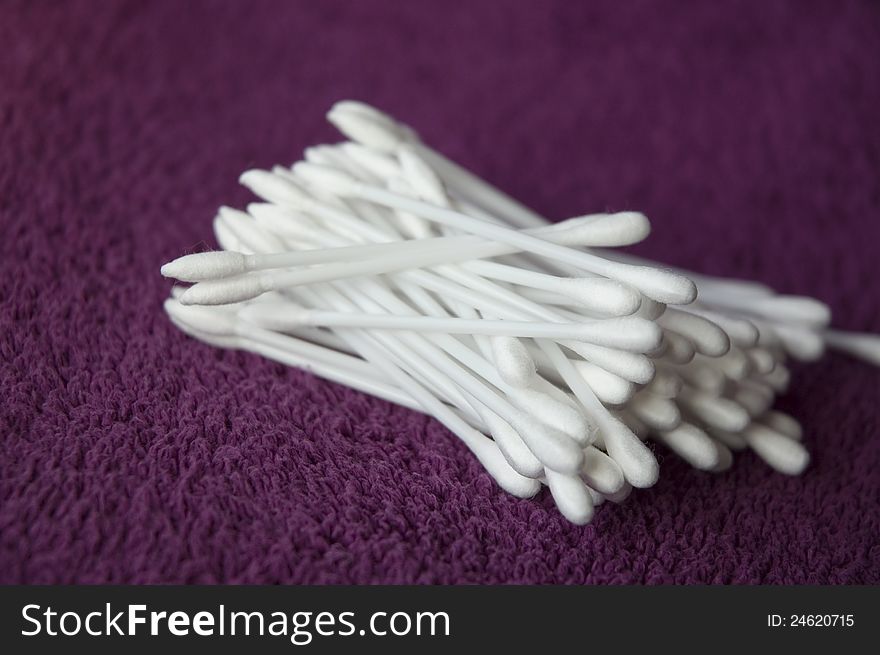 White cotton stick on violet towel