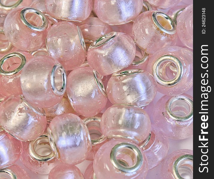 A grouping of pink foil glass beads for jewelry making or for art & crafts.