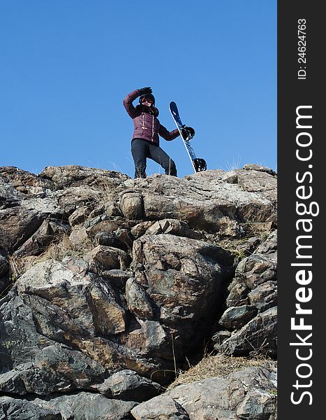 The girl with a snowboard on mountain top