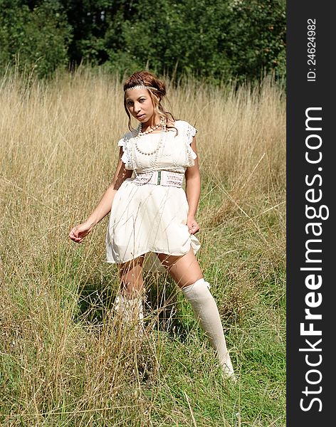 A beautiful girl wearing a flowing short summer dress and long white socks in a secluded meadow !. A beautiful girl wearing a flowing short summer dress and long white socks in a secluded meadow !