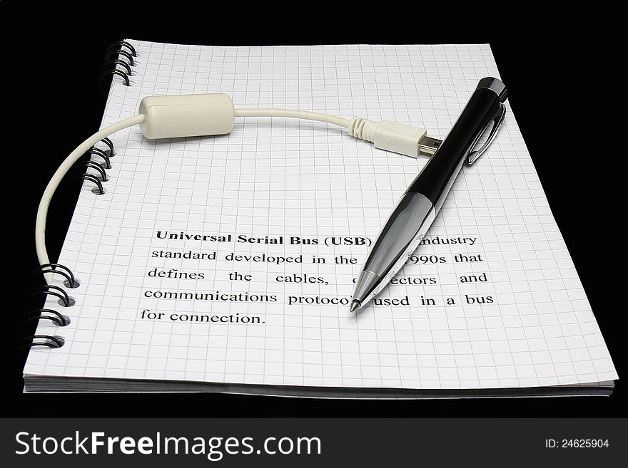 Pen and USB cable on black background
