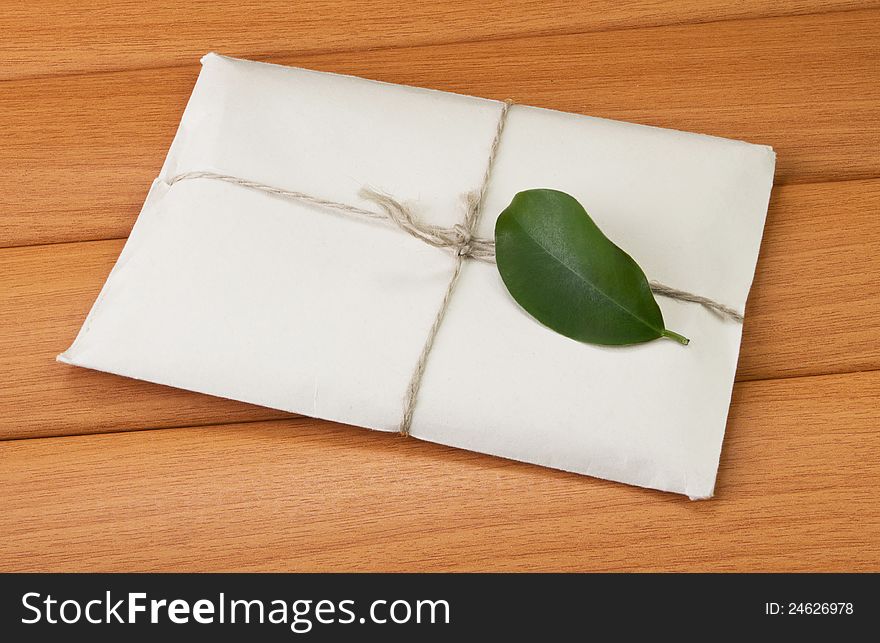 Paper letter with a green leaf on the tree against the background. Paper letter with a green leaf on the tree against the background