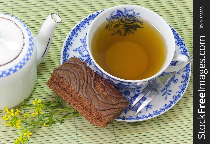 Cup of tea, the teapot and chocolate chip cookie