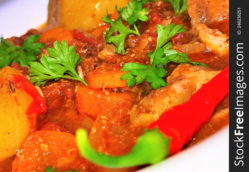 Beef goulash with potatoes, beef, tomato sauce, parsley and hot peppers yam