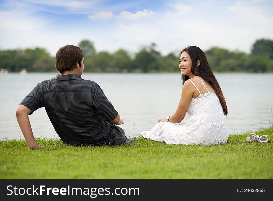 Couple enjoying the day sitting at the lake. Couple enjoying the day sitting at the lake