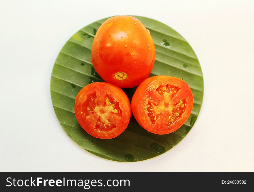 Fresh sliced tomatos on green banana leaf