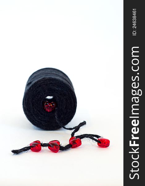Black spool and red glass hearts an white background. Black spool and red glass hearts an white background