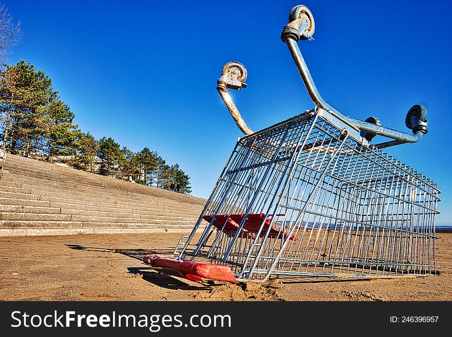 Shopping Trolley Upside-down On Beach.