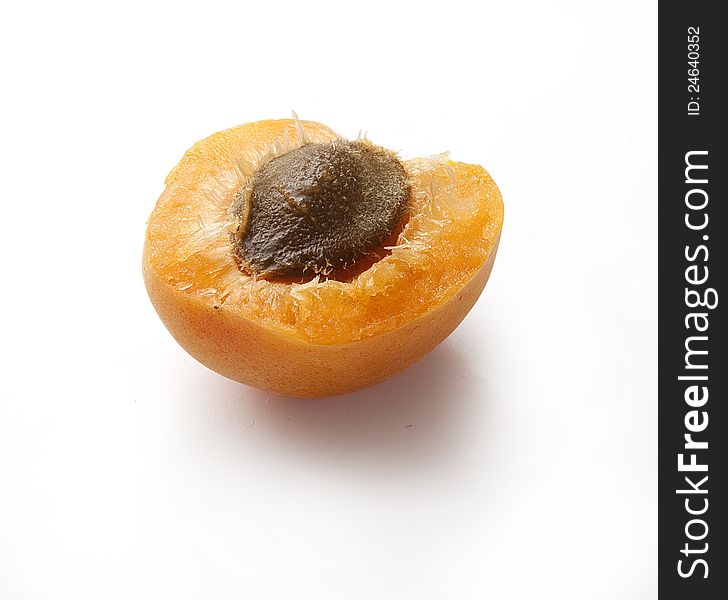 One cut off apricot with stone on the white. One cut off apricot with stone on the white