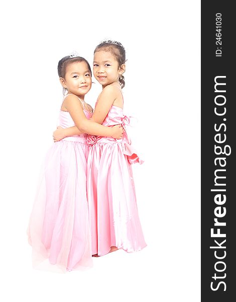 Two Asian girls in pink dress hugging each other