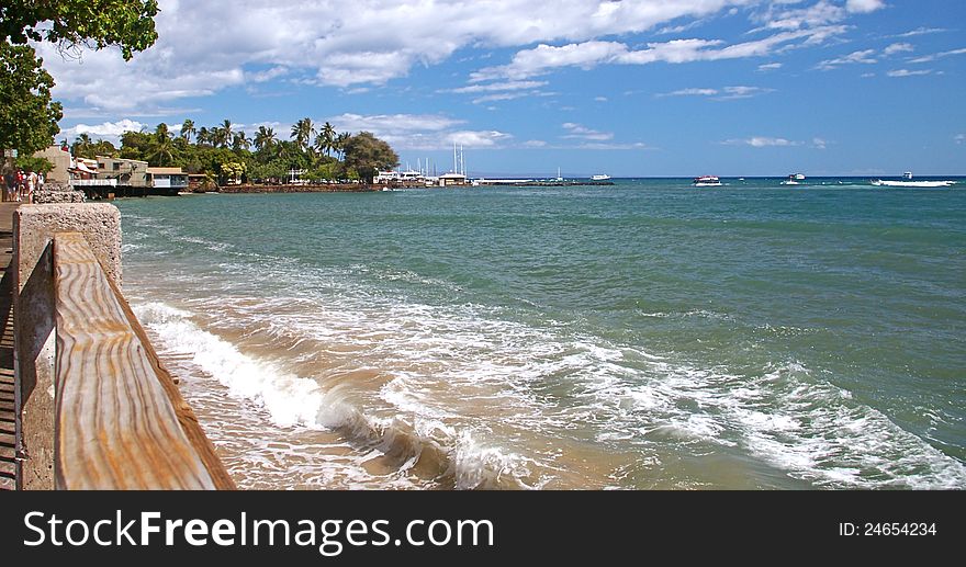 Breaking waves in the foreground, Lahaina Harbor in the background along the popular Front Street on Maui, Hawaii. Breaking waves in the foreground, Lahaina Harbor in the background along the popular Front Street on Maui, Hawaii