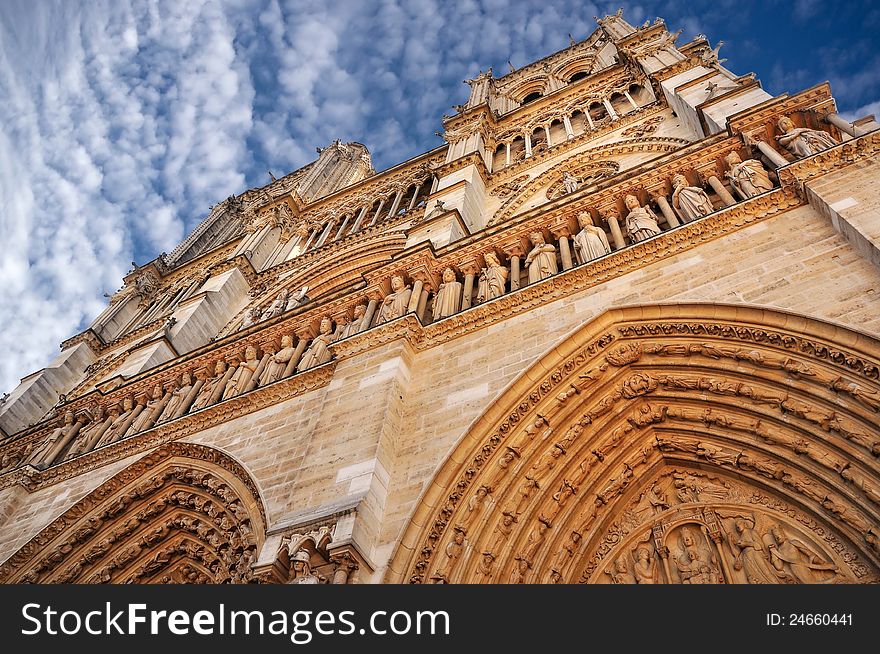 Notre Dame cathedral in Paris, daylight view with blue sky and white clouds