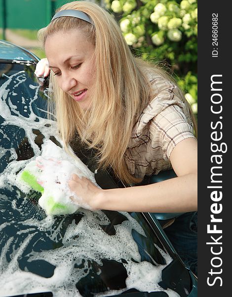 Young woman washing her car