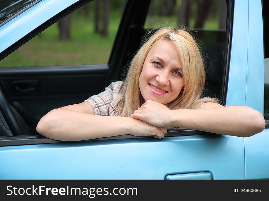 Smiling young  woman in the car