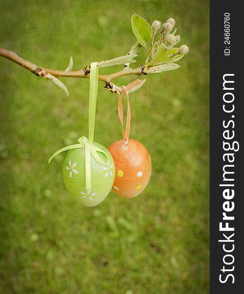 Decorative Easter eggs on a pear branch with green background