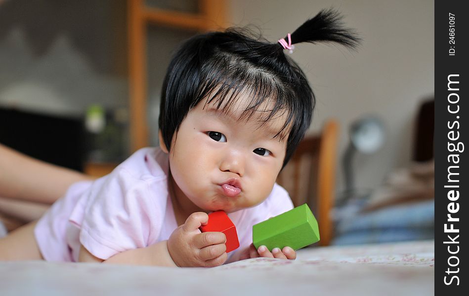 A 12 months chinese Baby girl Pull a face on the bed