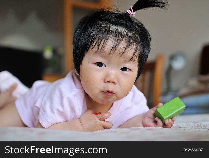 A 12 months chinese Baby girl Pull a face on the bed